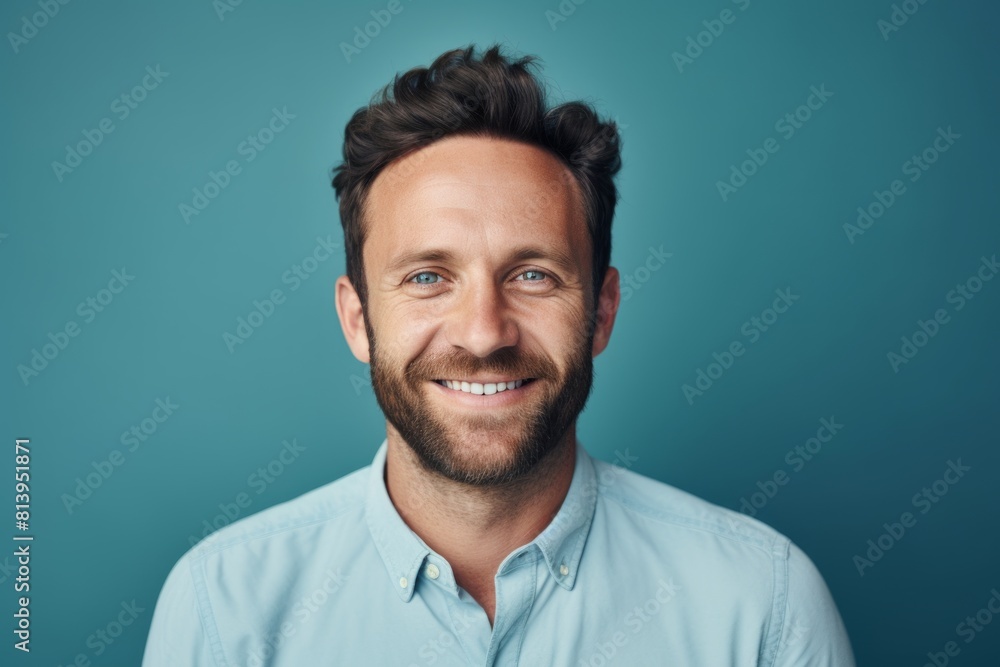 Portrait of a blissful man in his 30s smiling at the camera isolated on pastel blue background Portrait of a blissful man in his 30s smiling at the camera isolated on pastel blue background