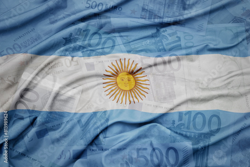 waving colorful national flag of argentina on a euro money banknotes background. finance concept.