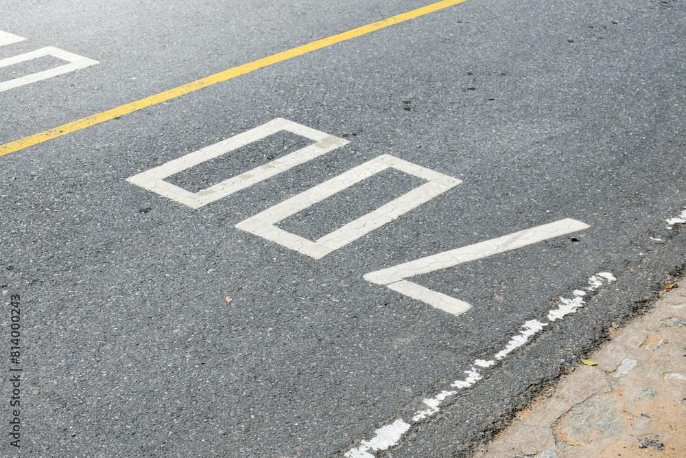 Road surface and yellow traffic lines with numbers seven hundred or 700 on soft sunlight background. Road surface and yellow traffic lines with numbers seven hundred or 700 on soft sunlight background.