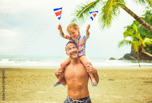 man holding costa rica flag screaming with his daughter on a Costa Rica beach