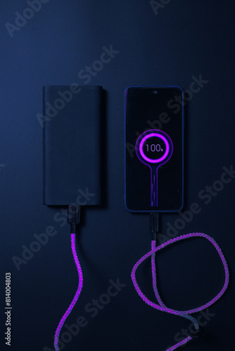 smartphone connected to powerbank on neon charger