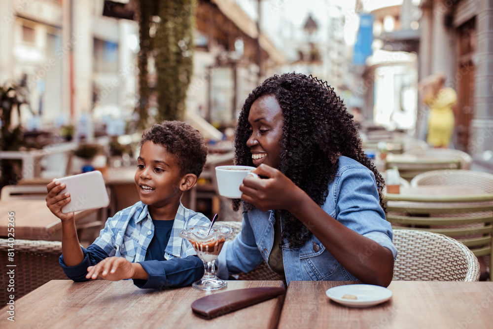 Black mother and son taking a selfie at a cafe Black mother and son taking a selfie at a cafe