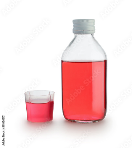 Medical for throat in glass bottle and measuring cup isolated.