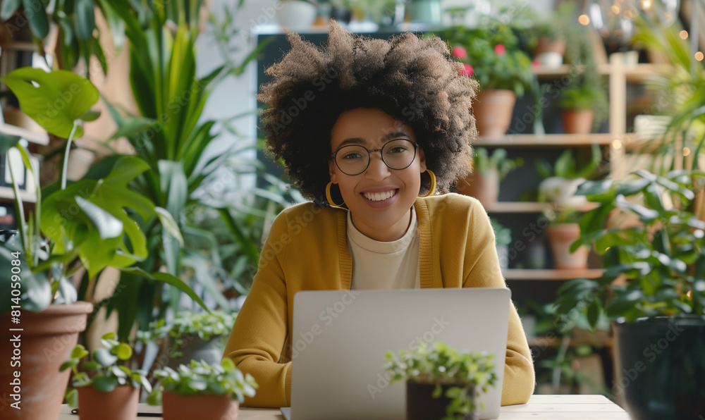 A smiling mixed-race woman works remotely using a virtual video call. A smiling mixed-race woman works remotely using a virtual video call.