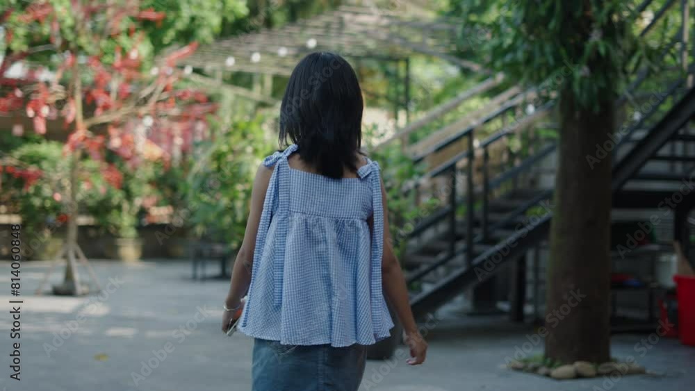 slow motion young asian teenage girl walking alone calm and happy on the terrace on a sunny summer day with her smartphone in her hand slow motion young asian teenage girl walking alone calm and happy on the terrace on a sunny summer day with her smartphone in her hand