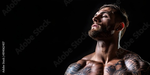 Portrait of a strong man in a tattoo studio on a black background. Concept Portrait Photography, Strong Man, Tattoo Studio, Black Background © Anastasiia