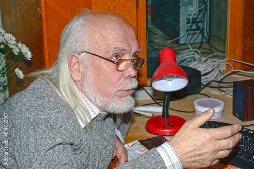 Portrait of senior man that is sitting at the desk.