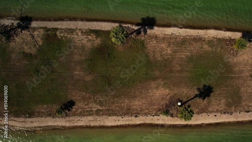 top view of the wakepark. the drone rises above the wakepark wakeboarders ride in a circle on the water in the middle palm trees grow on the island. High quality 4k footage photo