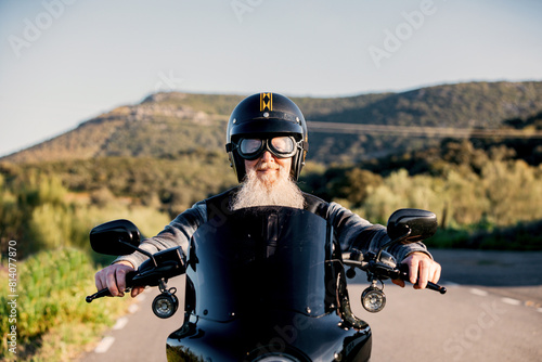 Senior biker with beard enjoying a ride photo