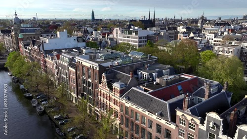 Historical Center of Amsterdam, Netherlands. Aerial Drone Shot of Traditional Dutch houses on narrow street and channel. photo