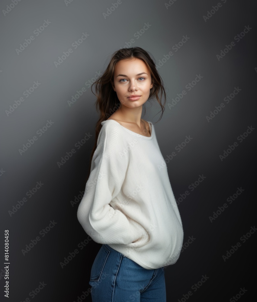 A brunette with wavy hair and a fleeting smile in light clothes on a gray background. Women's fashion and beauty, confident strong woman. A brunette with wavy hair and a fleeting smile in light clothes on a gray background. Women's fashion and beauty, confident strong woman.