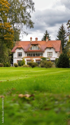a cozy, modern European-style family home nestled amidst lush green grass in its yard, with a clean, neutral background highlighting the beauty of its natural surroundings.