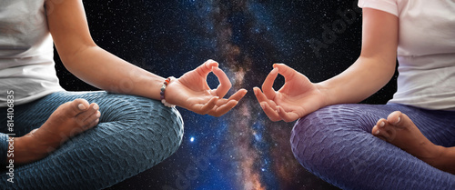 Two woman meditating with the universe in the background