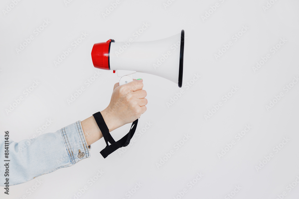Woman hand holds magaphone or loud speaker over white background