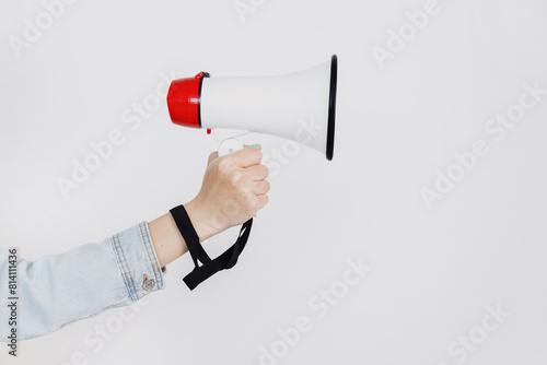Woman hand holds magaphone or loud speaker over white background