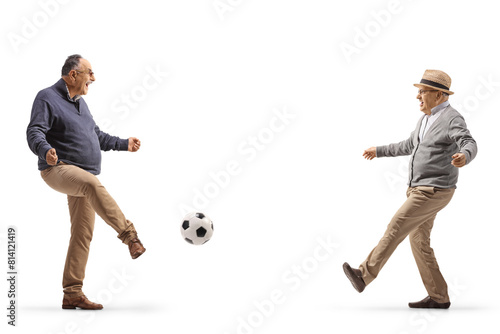 Two mature men kicking football
