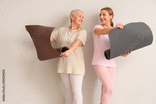 Mature women with yoga mats...