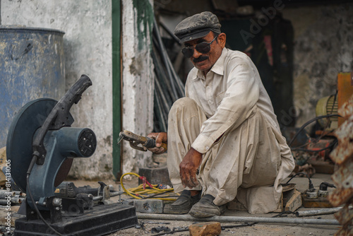 Poor old aged Pakistani welder working in his workshop
