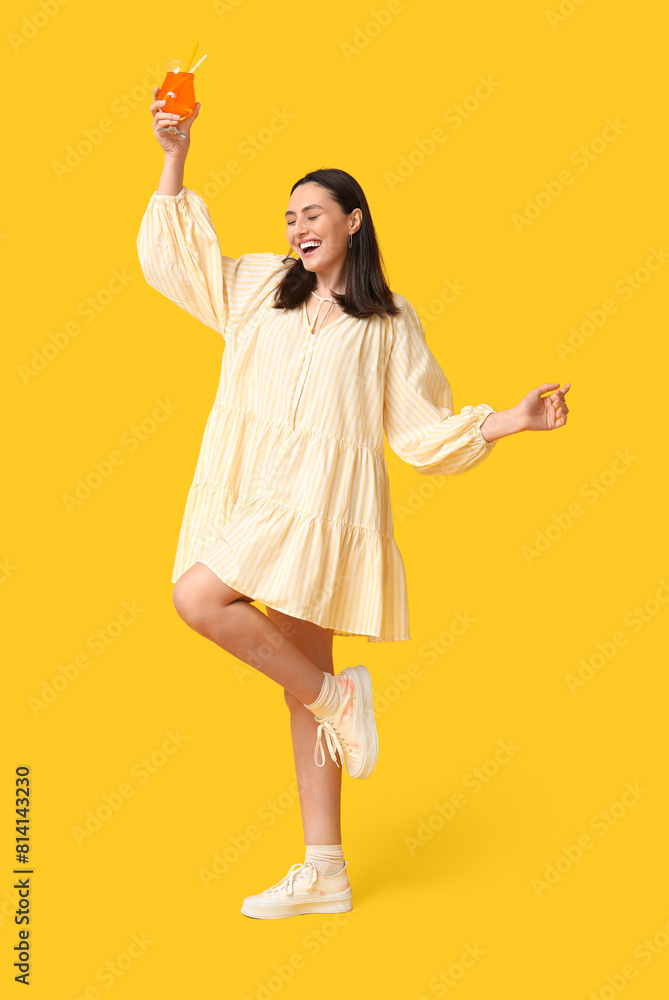 Beautiful young woman with glass of cocktail on yellow background. Summer party Beautiful young woman with glass of cocktail on yellow background. Summer party
