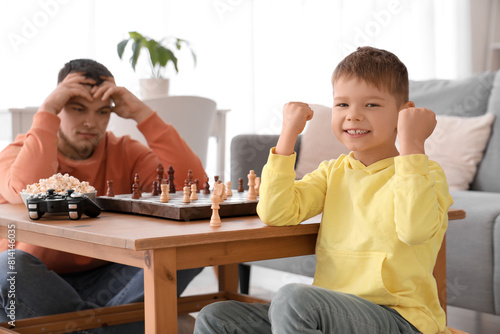 Little boy won game of chess against his father in living room