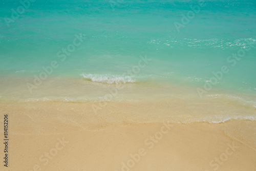 Waves and foam on a tropical sandy beach.