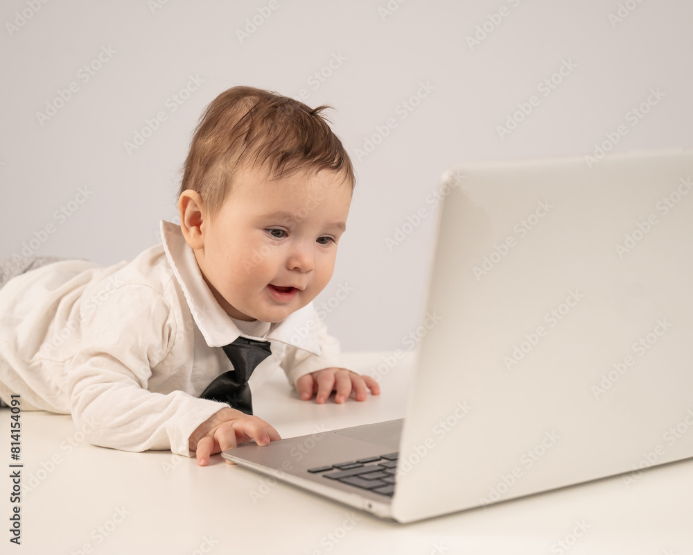 Cute baby boy in a tie working at a laptop. Cute baby boy in a tie working at a laptop.