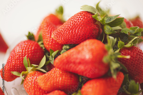 Closed up of fresh strawberry. Red Strawberries in a Bowl Ready to Eat. Strawberries laying in heap in white glass plate. 