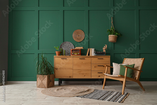 Interior of room with armchair and vintage typewriter on commode photo