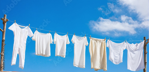 Against the backdrop of blue sky, laundry and clothing sway gently on clotheslines, drying in the breeze. Freshness and a natural scent, creating a cozy scene of domestic comfort under the open sky