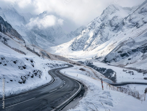 A picturesque snowy road weaves through the breathtaking mountain landscape under a sky of blue. © Szalai