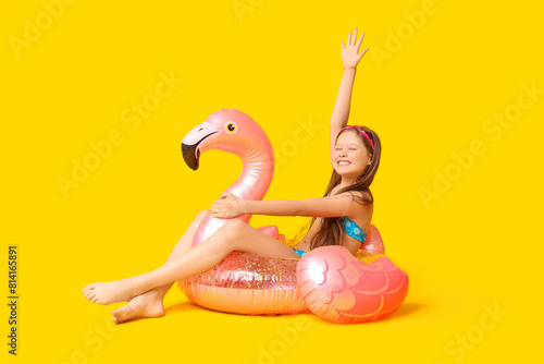 Fotografía Cute little happy girl in swimsuit with inflatable ring and goggles sitting on y