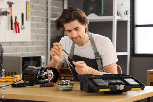 Male worker with soldering ...