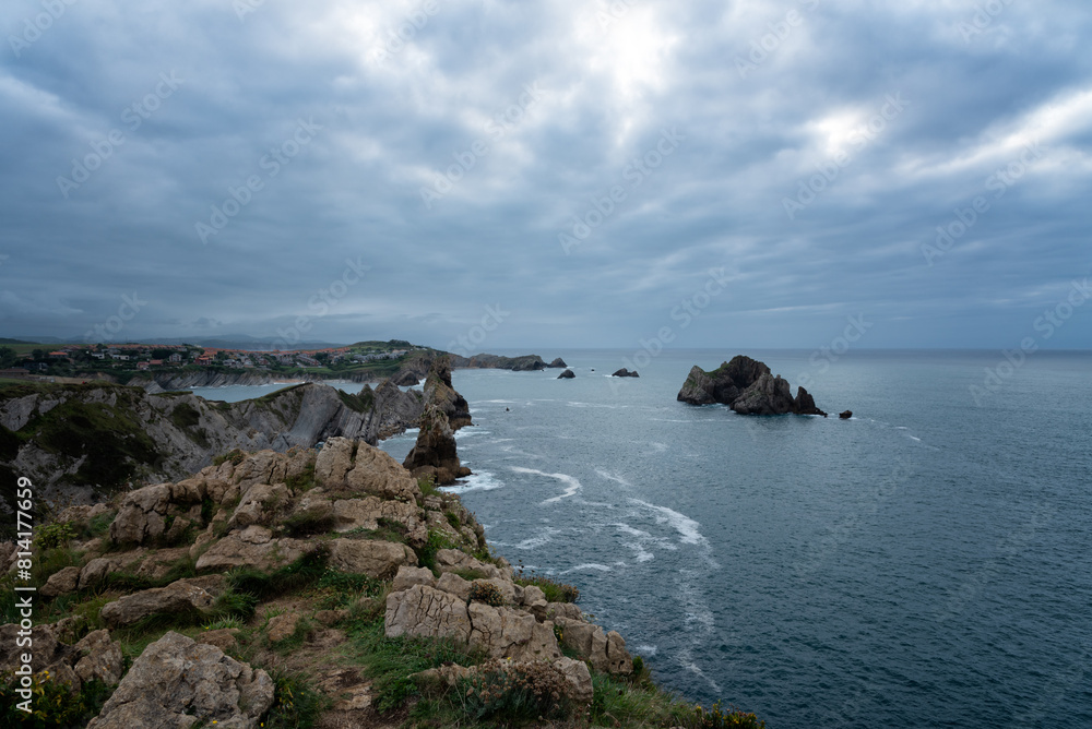 A rocky shoreline with a cloudy sky and a body of water, Costa Quebrada, Urros de Liencres, Cantabria, Spain. A rocky shoreline with a cloudy sky and a body of water, Costa Quebrada, Urros de Liencres, Cantabria, Spain.