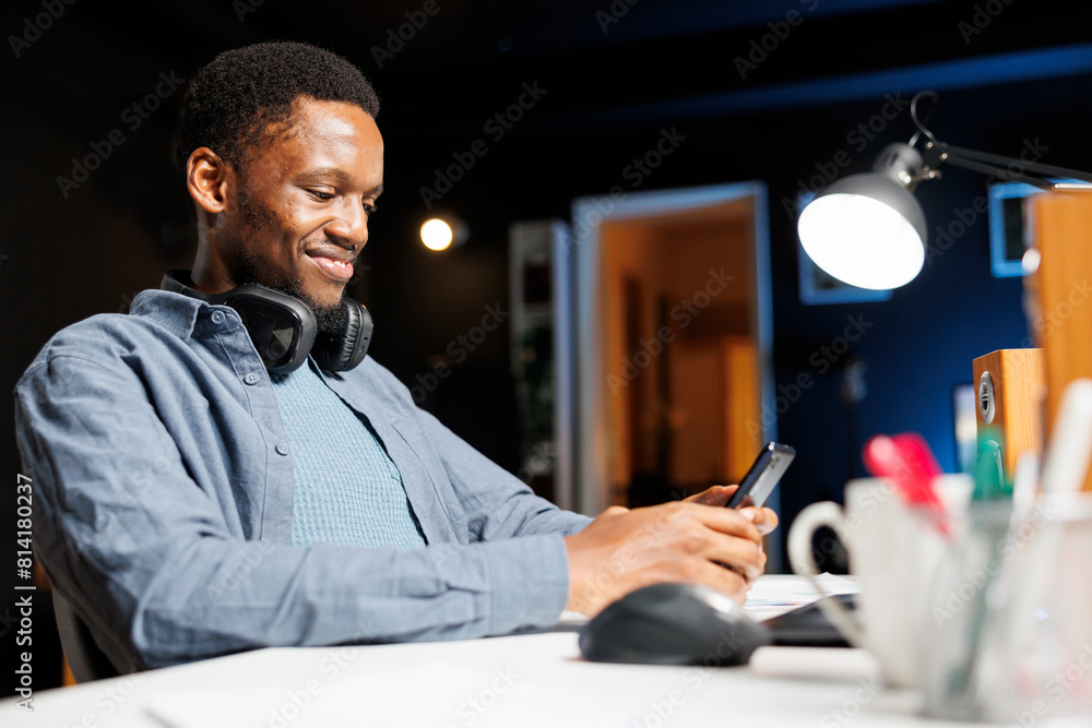 Fototapeta premium Male student sending sms online on mobile phone, attending professional training course on internet network. Young adult browsing social media sites and joining web training class program.