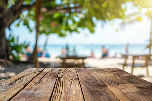  focus is on the wooden texture of a tabletop at a beachside bar, with a blurred background revealing thatched umbrellas, tropical trees, and the calm blue sea on a sunny day, holiday photo
