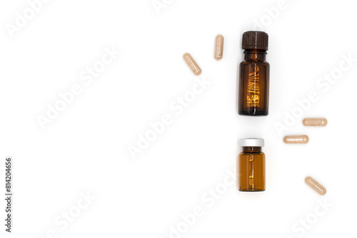 Aromatherapy, face and body care, bottles with essential oils, vitamin tablets on white background, flat lay, top view
