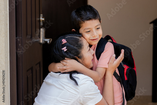 Hispanic mom hugging her little son ready for his first day of school- Child with her mother ready to go to school- Back to school in Latin America