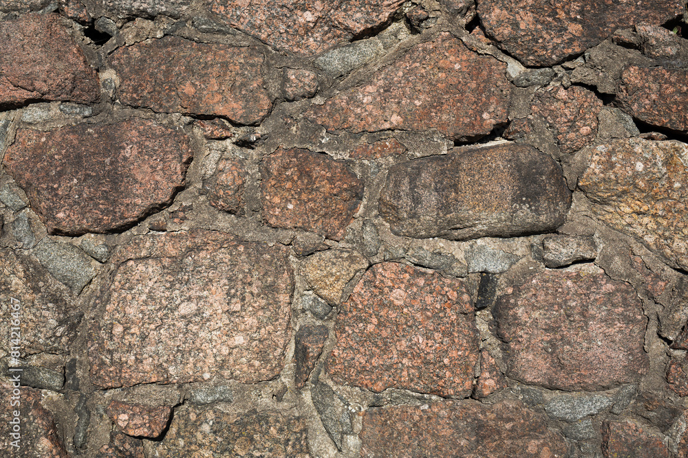 Ancient stone wall. Weathered rough surface of old masonry. Granite rock. Wall of a medieval castle. Vintage texture great for background and design. Ancient stone wall. Weathered rough surface of old masonry. Granite rock. Wall of a medieval castle. Vintage texture great for background and design.