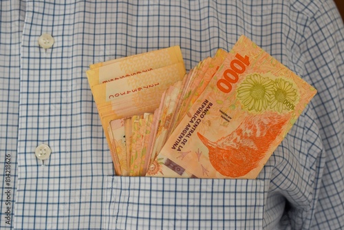 many 1000 argentine peso bills stuffed into a shirt pocket