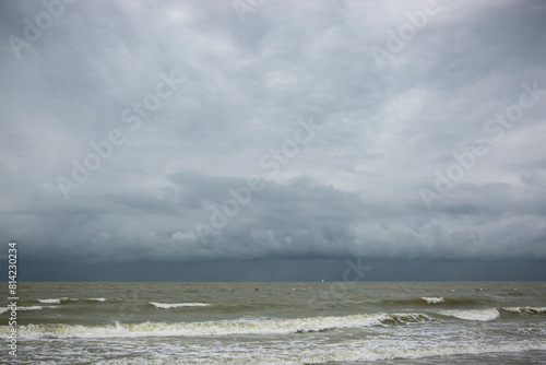 Schlechtes Wetter am Meer mit Wellen, Wind und dunklen Wolken photo