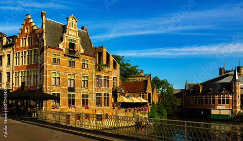 View of picturesque blooming area with typical residential buildings in historic center of Ghent city along Leie river on summer day, Belgium