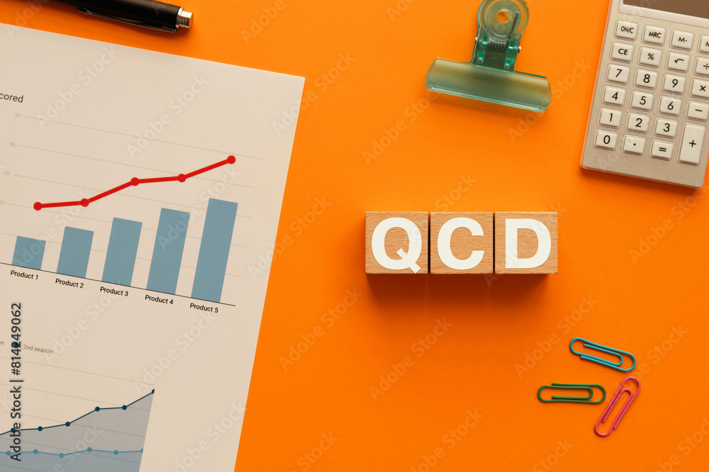 There is wood cube with the word QCD. It is an abbreviation for Quality, Cost, Delivery as eye-catching image.