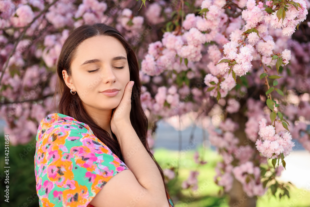 Fototapeta premium Beautiful woman near blossoming tree on spring day