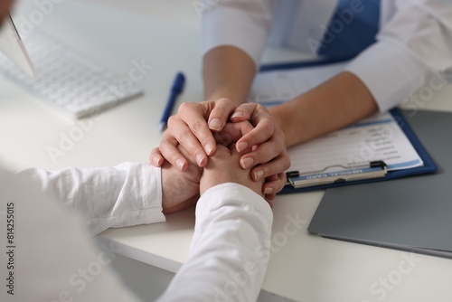 Professional doctor working with patient at white table in hospital, closeup