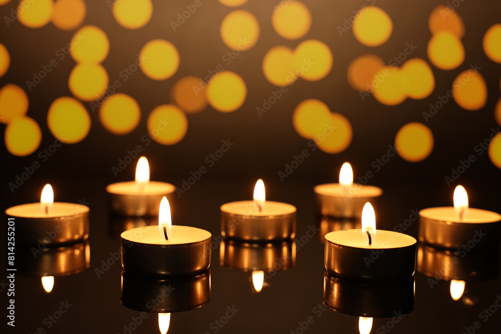 Burning candles on mirror surface in darkness, bokeh effect Burning candles on mirror surface in darkness, bokeh effect