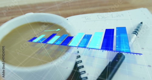 Image of growing graphs over coffee and pen on to do list in notepad on wooden table