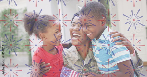 Image of fireworks over happy african american soldier mother hugging kids