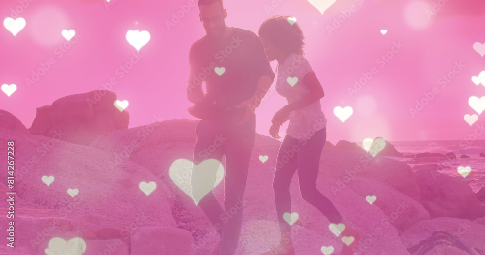 Image of heart icons over biracial couple at beach Image of heart icons over biracial couple at beach