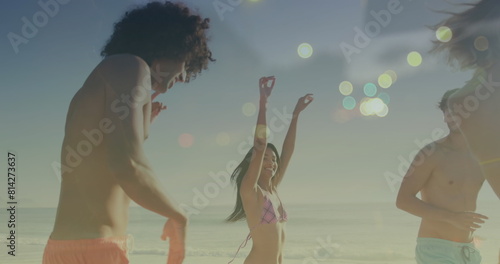 Image of light spots over happy diverse friends dancing at beach