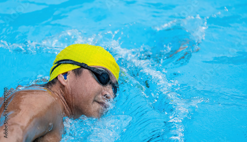 Asian male athlete swimming in the pool